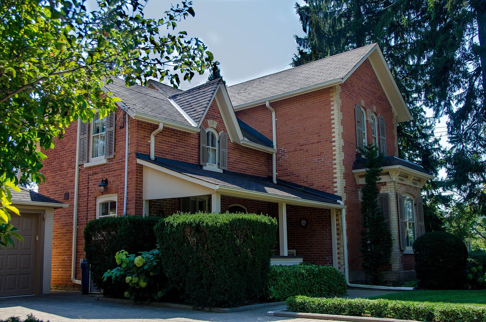 Two-storey red-brick 19th-century house with gables and a front porch, Oakville